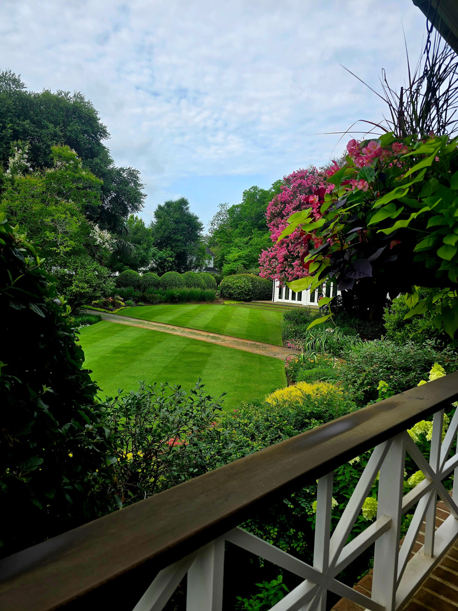 A maintained garden and lawn seen from the porch, with shrubs kept in scale