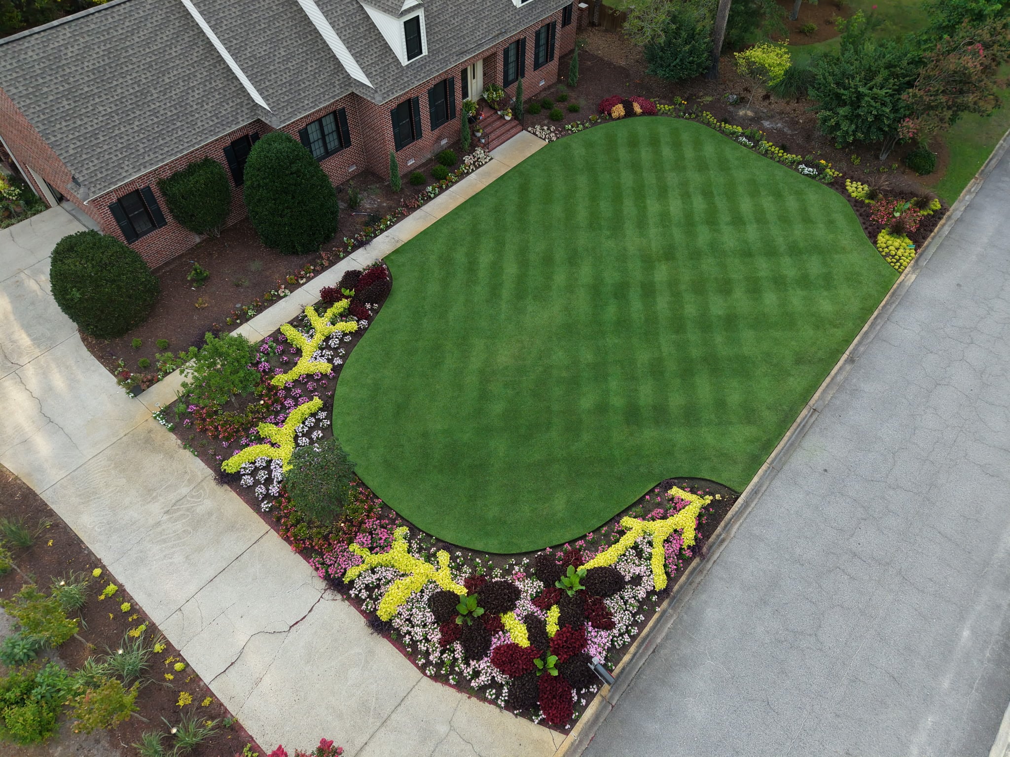 Maintained striped lawn and planting beds after seasonal cleanup