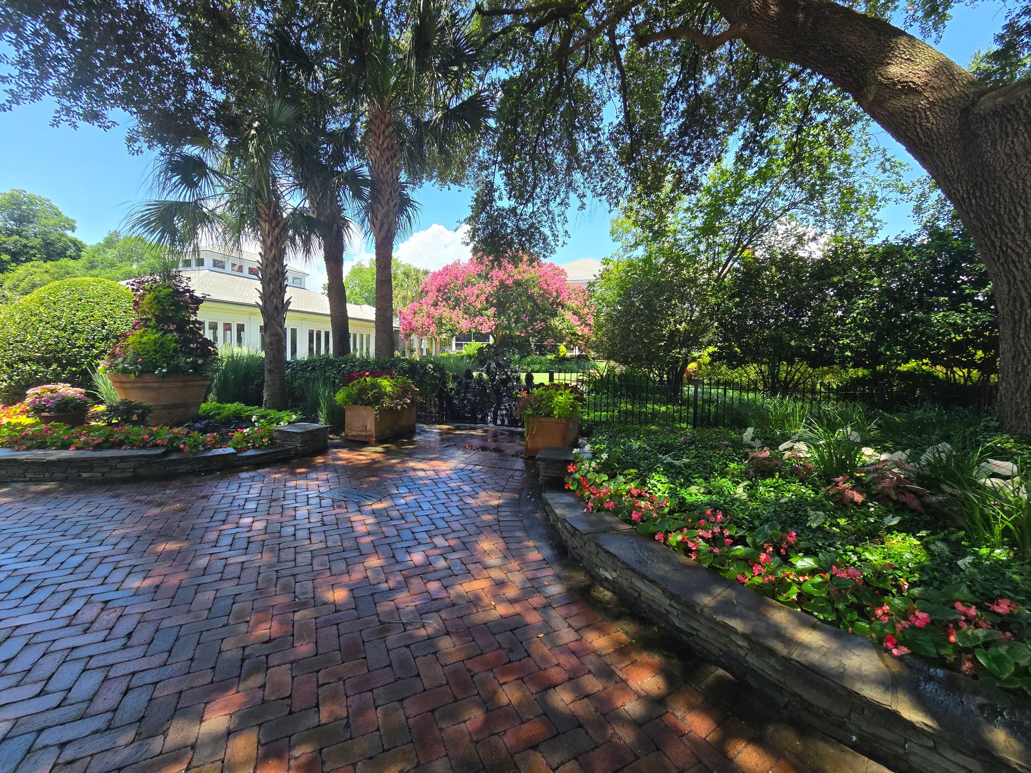 Herringbone brick courtyard with stone edging, planters, and planting beds